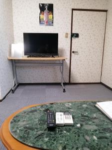 泉大津市Minpaku Yamamoto - Vacation STAY 13870的一张桌子,桌子上有两个遥控器,电视机