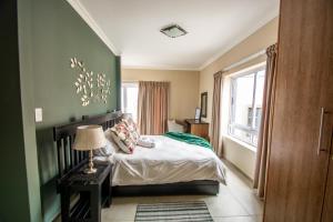 LangstrandLong Beach Selfcatering Namibia的一间卧室配有一张带绿色墙壁的床