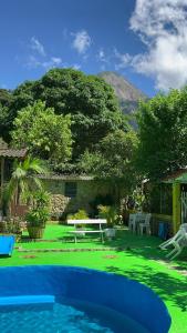 瓜皮米林Suíte serra dos órgãos guapimirim的后院设有带桌子和长凳的游泳池