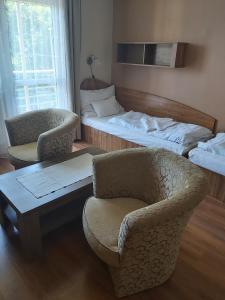 索普隆阳光俱乐部酒店的客房设有两张床、椅子和桌子。
