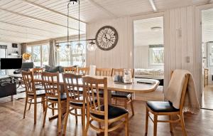 北内伯尔Nice Home In Nrre Nebel With Sauna的一间带桌椅和时钟的用餐室