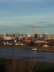 诺伊斯Crowne Plaza Düsseldorf - Neuss, ein IHG Hotel的享有河流和城市美景
