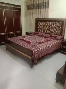 GujrātGujrat Guest House的一间卧室配有一张红色床罩的床