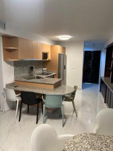 波拉马尔Edificio Solarium的厨房配有桌椅和冰箱。