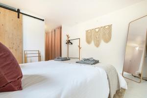 滨湖埃斯塔瓦耶Retraite Bohème - Projecteur, Netflix, Lac Proche的卧室配有白色的床和镜子