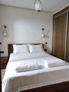 阿加迪尔Hivernage, Superbe appartement dans une résidence的卧室配有白色的床和2个枕头