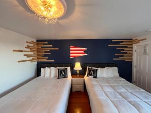 巴港Acadia Ocean View Hotel的卧室设有两张床铺,拥有蓝色的墙壁