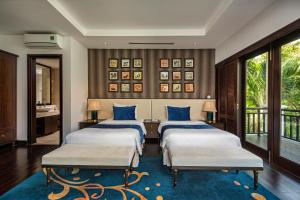 岘港Abogo Champa Villa Beach Da Nang的一间卧室配有三张床和蓝色枕头