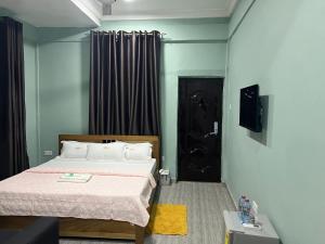 海岸角Jackie Grand Hotel的一间卧室设有一张床和一个黑色的门