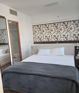 圣保罗Get a Flat 1403 localização Nobre的卧室配有一张白色大床和镜子