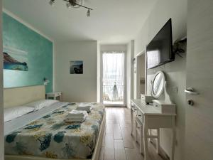 费扎诺Fezzano / Portovenere Stilish double rooms with sea view, balcony or small courtyard的一间卧室配有一张床、一张书桌和一台电视