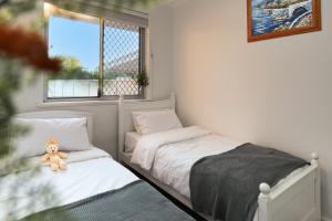 珀斯Cozy 5 bed House Nr Airport/DFO/Casino的一间卧室配有两张床,卧室上摆放着泰迪熊