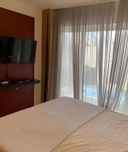 圣保罗Get a Flat 701 - Ibirapuera -Jardins的一间卧室设有一张床和一个大窗户