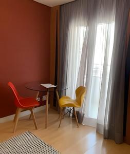 圣保罗Get a Flat 701 - Ibirapuera -Jardins的一间设有两把椅子、一张桌子和一个窗户的房间