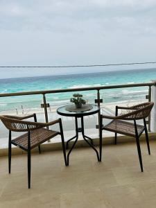卡利塞亚-豪客迪克斯Afrodite Seaside Rooms的阳台配有一张桌子和两把椅子,享有海景