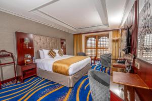 麦地那达尔塔夸酒店的酒店客房,配有一张床和一些椅子