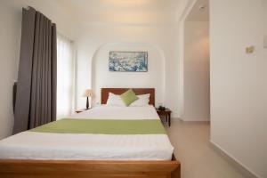 胡志明市Ngọc Châu Hotel的卧室配有一张带窗户的绿色白色床。