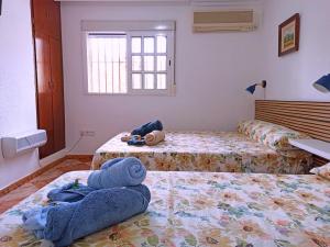 塞维利亚El Azahar的卧室配有两张床和毛巾,位于地板上