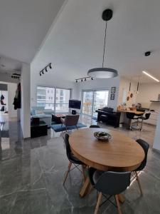 哈德拉Beach front luxury apartment - managed building的客厅配有木桌和椅子