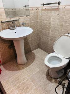 伊斯兰堡Madcrew Lodge的浴室配有白色卫生间和盥洗盆。