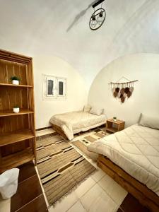 开罗3-Cozy Bedroom Haven l Free Horseback Tours的一间卧室设有两张床,天花板上设有时钟。