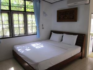 班邦宝宾泊普村庄酒店的一间带一张大床的卧室,位于带窗户的房间内
