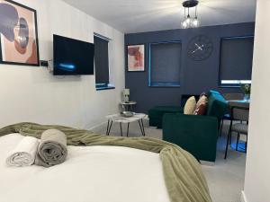 彼得伯勒Newark House Premium Apartments by DH ApartHotels的一间卧室设有一张床和一间客厅。