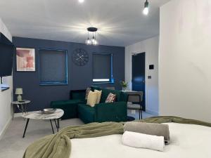 彼得伯勒Newark House Premium Apartments by DH ApartHotels的客厅设有绿色沙发和蓝色的墙壁。