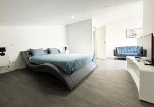 勒芒Residence Belfort的一间卧室配有一张床和一张蓝色的沙发