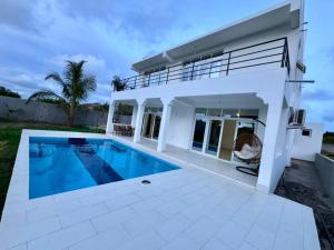 马林迪3 Bedrooms Apartment Own Compound - Malindi的一座白色的房子,前面设有一个游泳池