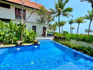 岘港Abogo Champa Villa Beach Da Nang的棕榈树屋前的游泳池