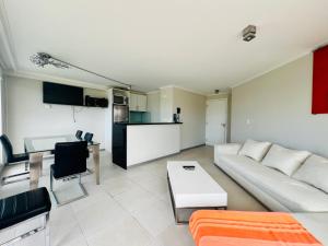 埃斯特角城Ocean drive 2 full amenities的一间带白色沙发的客厅和一间厨房