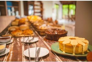 圣米格尔-杜斯米拉格里斯Angá Beach Hotel的盘子上带蛋糕和其他糕点的桌子