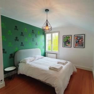 日内瓦Maison de charme au cœur de Genève !的一间卧室配有一张带绿色墙壁的床