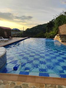 马尼萨莱斯Ecohotel Java的一个带桌子和遮阳伞的大型蓝色游泳池
