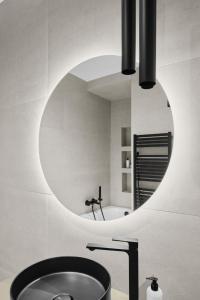 布达佩斯Hotel Collect & Residence的一间带圆形镜子和水槽的浴室