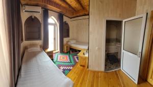 希瓦Khiva Siyovush Hotel的小房间设有一张床和一间浴室
