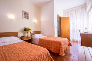 罗马卡萨特拉挪伊酒店的酒店客房设有两张床和窗户。