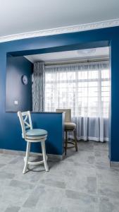 尼耶利The Fairway Residence的蓝色的客房配有椅子和桌子
