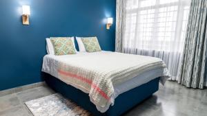 尼耶利The Fairway Residence的蓝色的卧室,配有一张蓝色墙壁的床