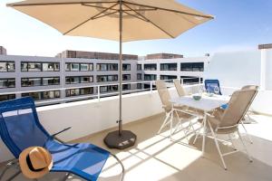 尼斯L17 Arenas Suite 3 balconies 5mins to the Sea的阳台配有桌椅和遮阳伞。