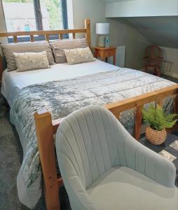 戈斯兰Englefield Guesthouse的一间卧室配有一张大床和一把椅子