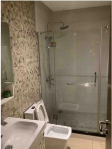 库马西Wynn Apt - Luxe / Uninterrupted Power / Near Mall / Sleeps 3的带淋浴、盥洗盆和淋浴的浴室