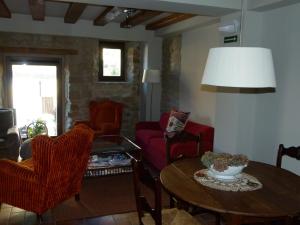 蓬特拉雷纳埃尔奇科酒店的客厅配有桌子和红色椅子