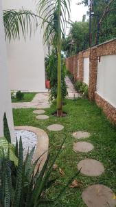 迪亚尼海滩Tranquil Pendo villas的院子里的一条带棕榈树的走道