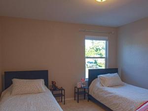 伯尼A Charming Hill Country Home的一间卧室设有两张床和窗户。