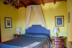 皮耶韦福斯切纳贝维德雷别墅酒店的一间卧室配有蓝色的床和2个床头柜