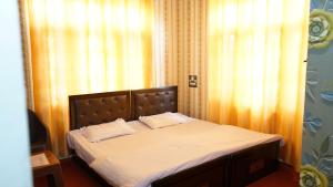 RājbāghGreen Resort的一张床上有两个枕头的房间