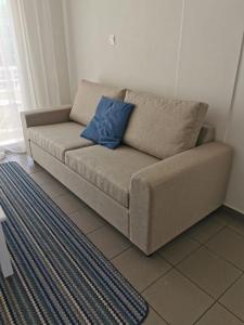 利马索尔Nostalgia apts的客厅的沙发,配有蓝色枕头