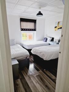 利兹2 Bedroom Cozy Chambers with free parking的带三张床和窗户的客房